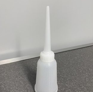 Fotografia di una pipetta "oliatore" in plastica bianca opaca semi trasparente