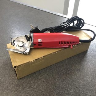Taglierina rotativa per il taglio/cucito, con lama di diametro 50 mm, appoggiata sulla sua confezione di cartone